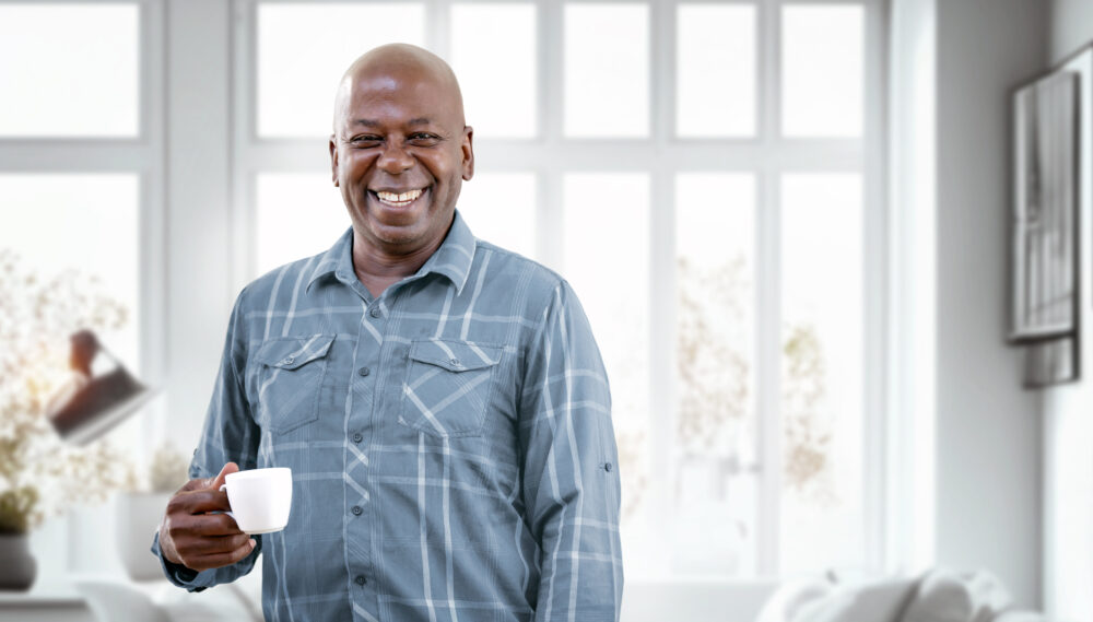 Happy Mature Black Man Drinking Coffee while relaxing at home. Retirement Lifestyle And Leisure Concept