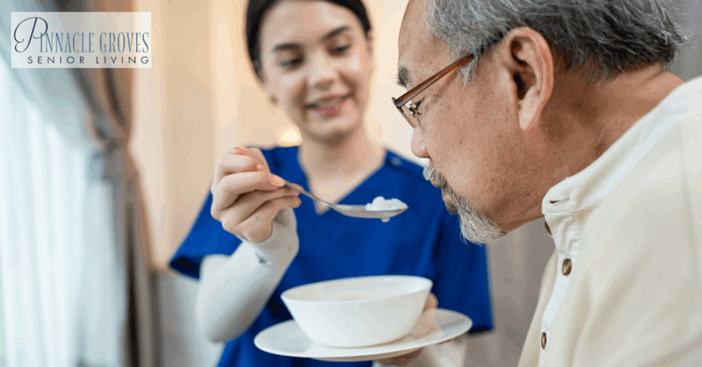 Dementia and eating. A care partner gently assists an elderly man with dementia in eating, demonstrating compassionate support during mealtime at a senior living community.